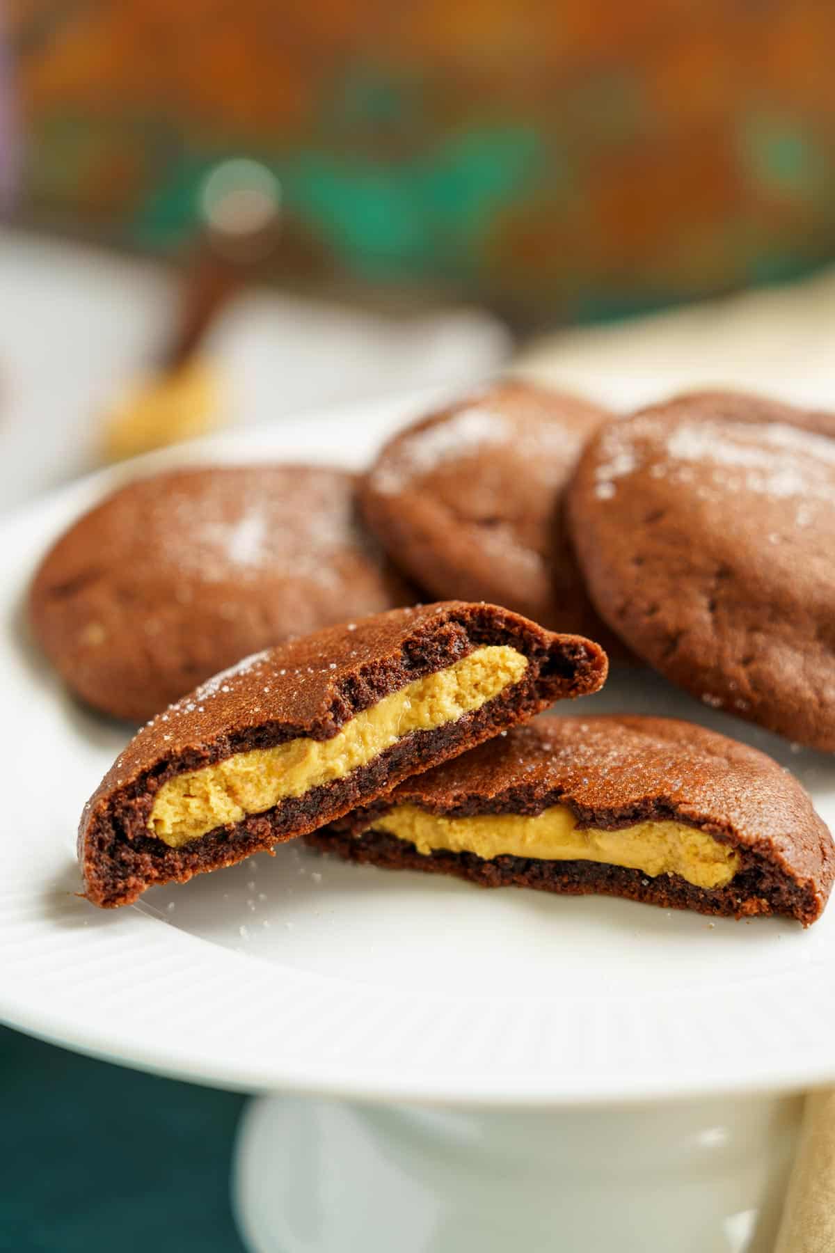 Full feature image of a split peanut butter stuffed chocolate cookie on a white plate.