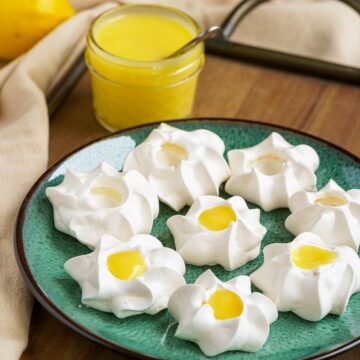 Some filled and some not filled meringue cookies with lemon curd.