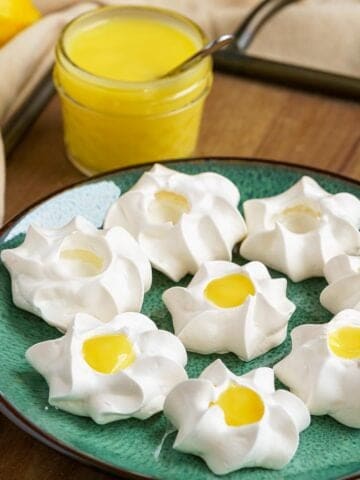 Some filled and some not filled meringue cookies with lemon curd.