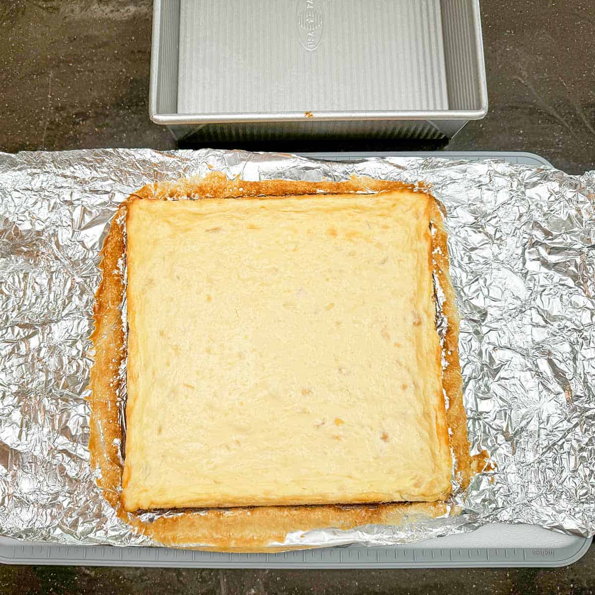 Lifted the cheesecake up by the handles and setting it on a cutting board.