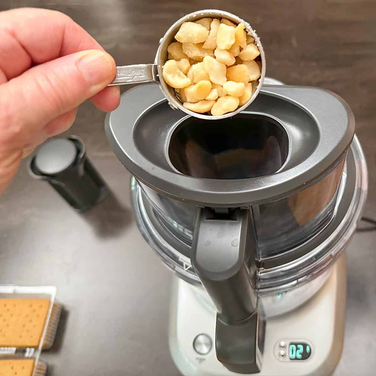 Adding the macadamia nuts to the food processor.