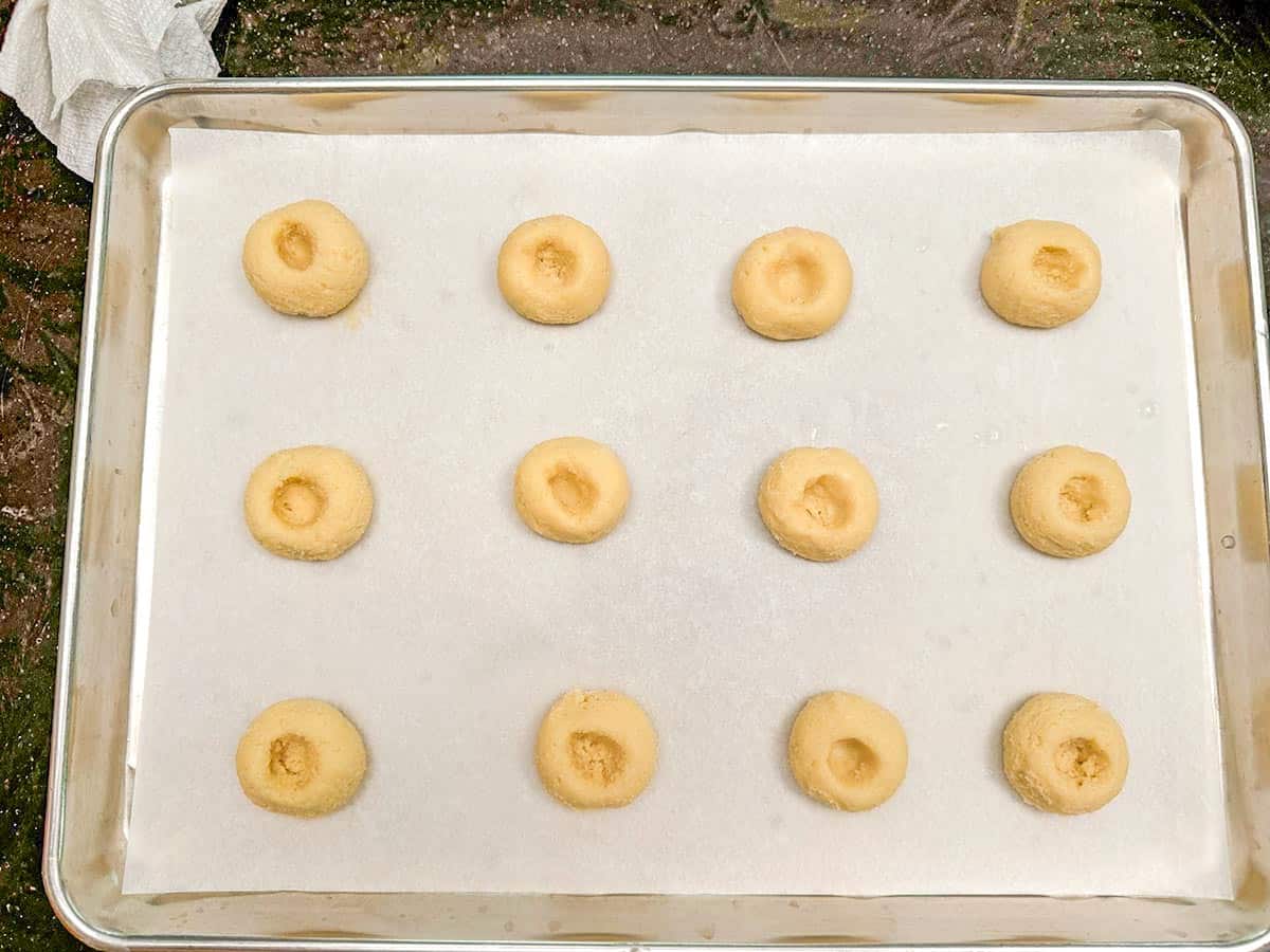 Twelve cookies that have wells added and will hold the fig mixture.