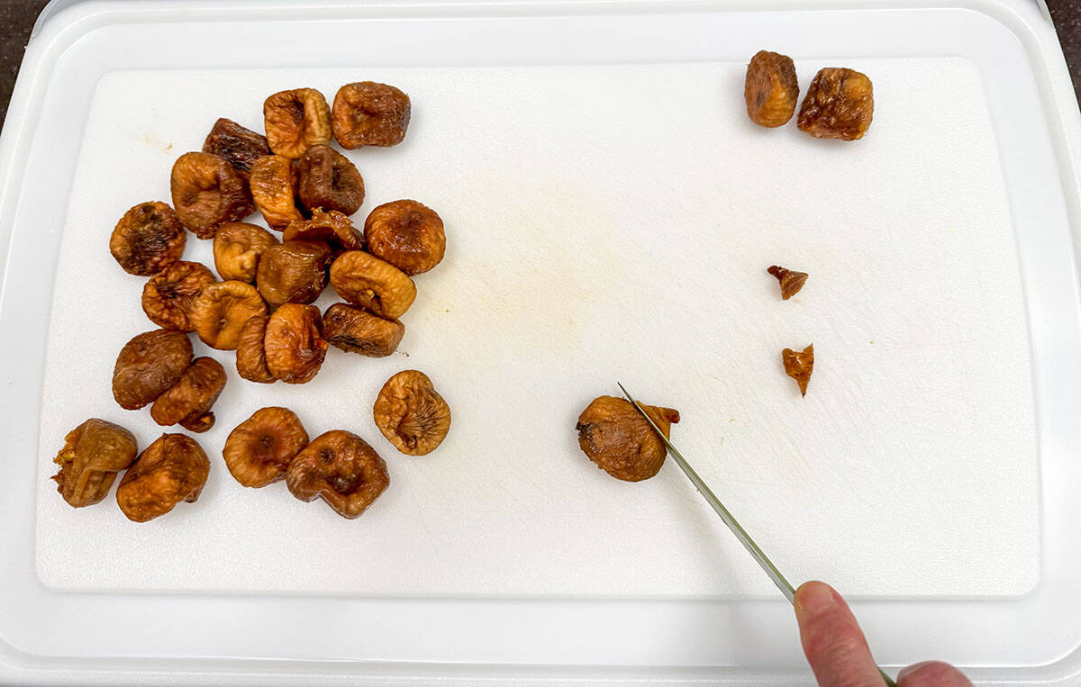 Cutting the stems off of the dried figs.