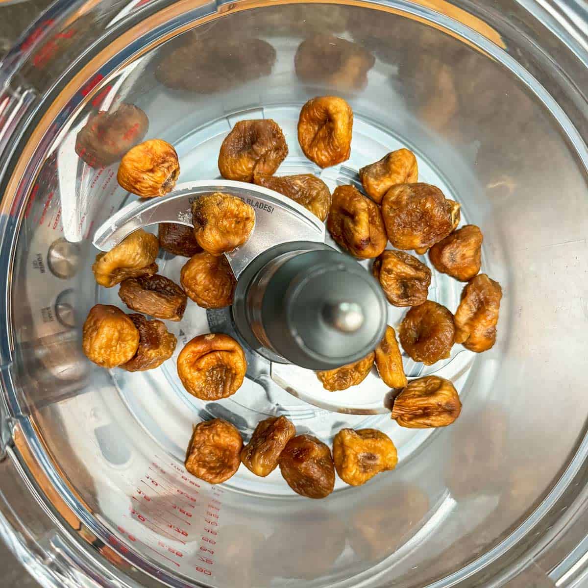 Whole dried figs in the food processor bowl.