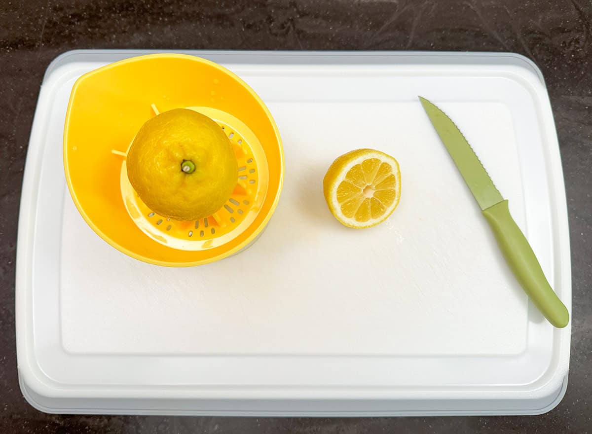 Lemon on a cutting board cut in half so you can juice it.