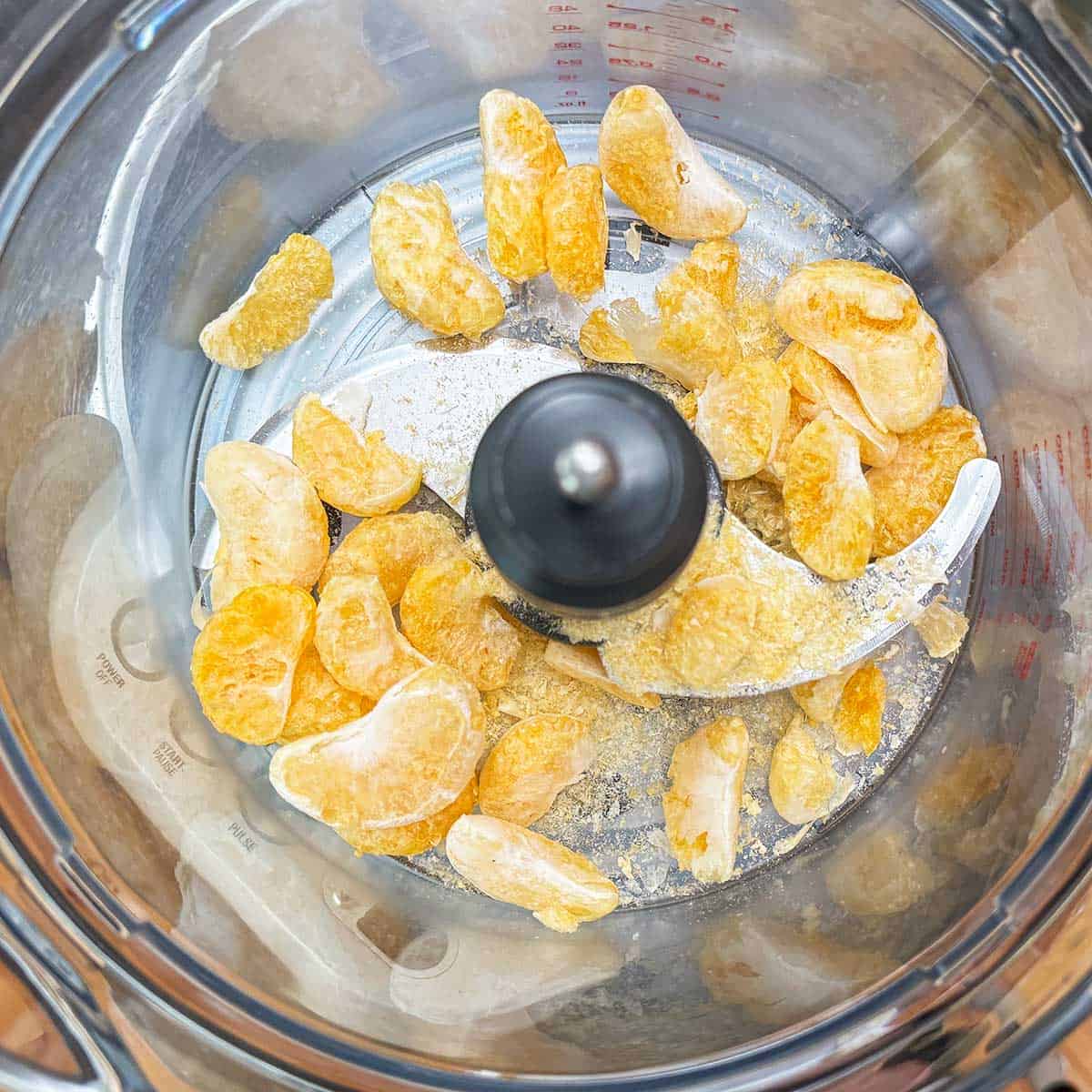 Freeze-dried tangerines in a food processor bowl.