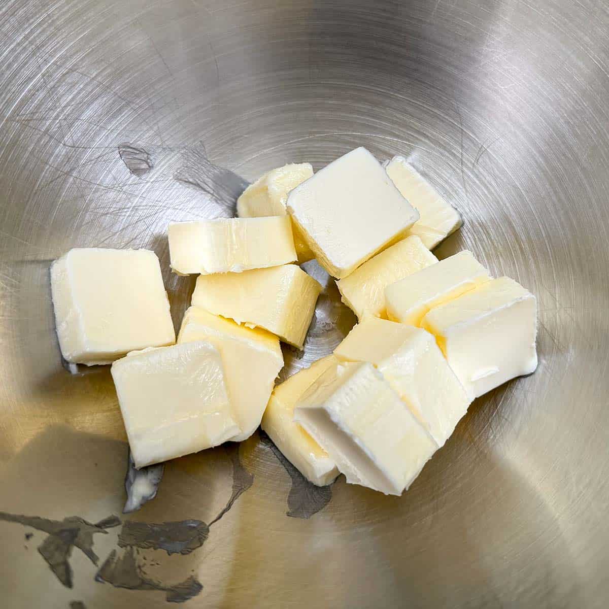 Soft butter cubed in a mixer bowl.