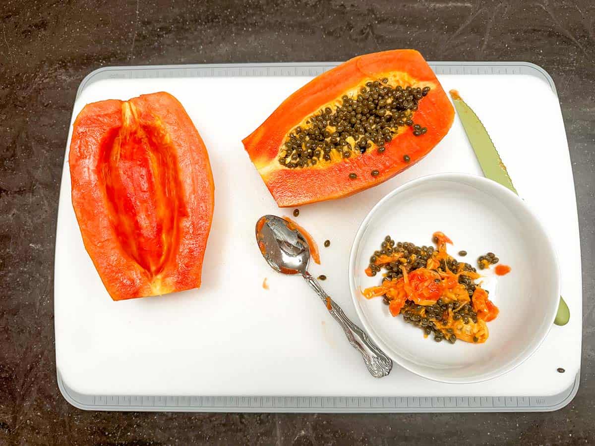 The papaya cut in half and the seeds taken out of one side.