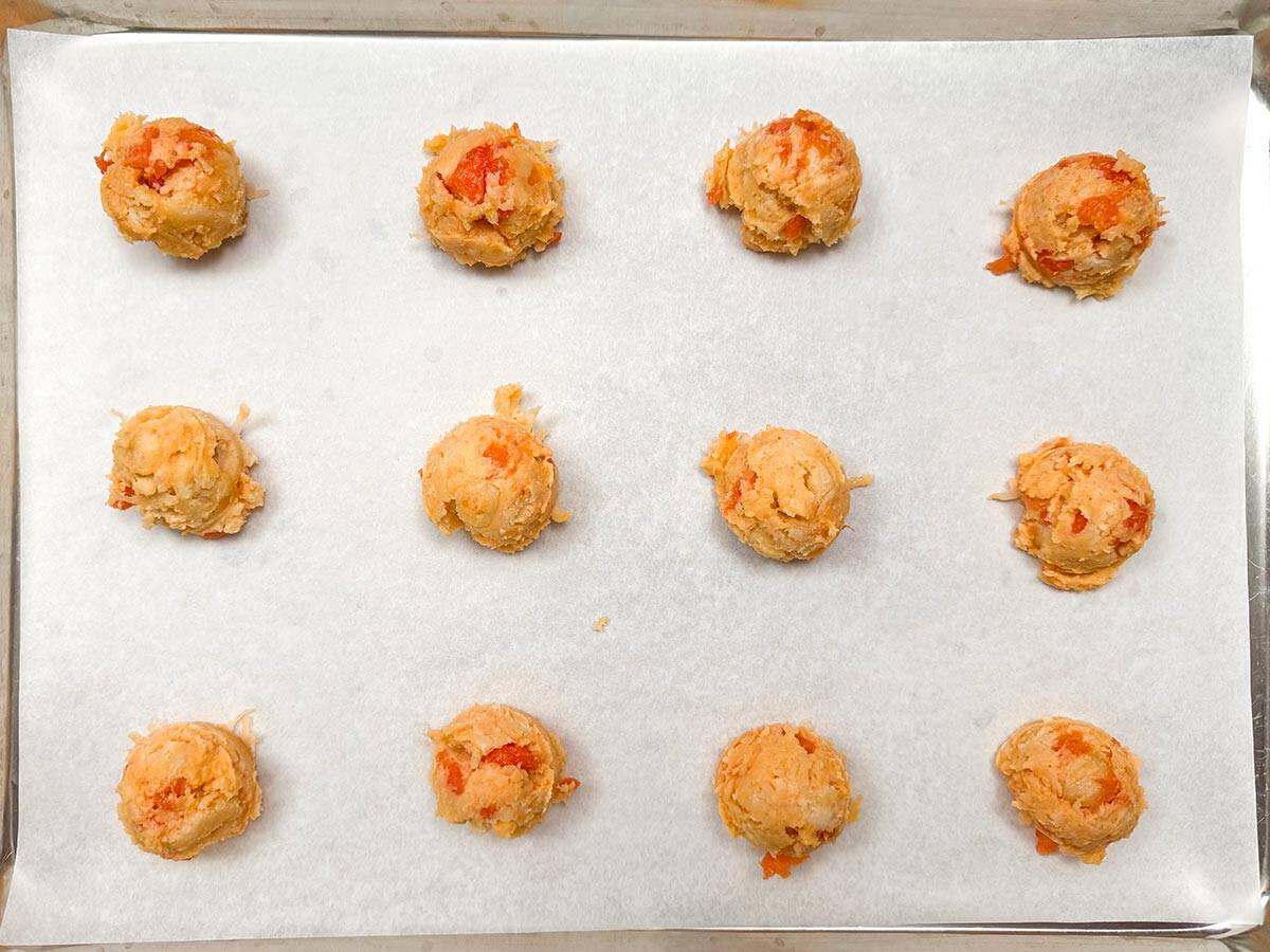 Cookies scooped and on a parchment-lined cookie sheet pan.