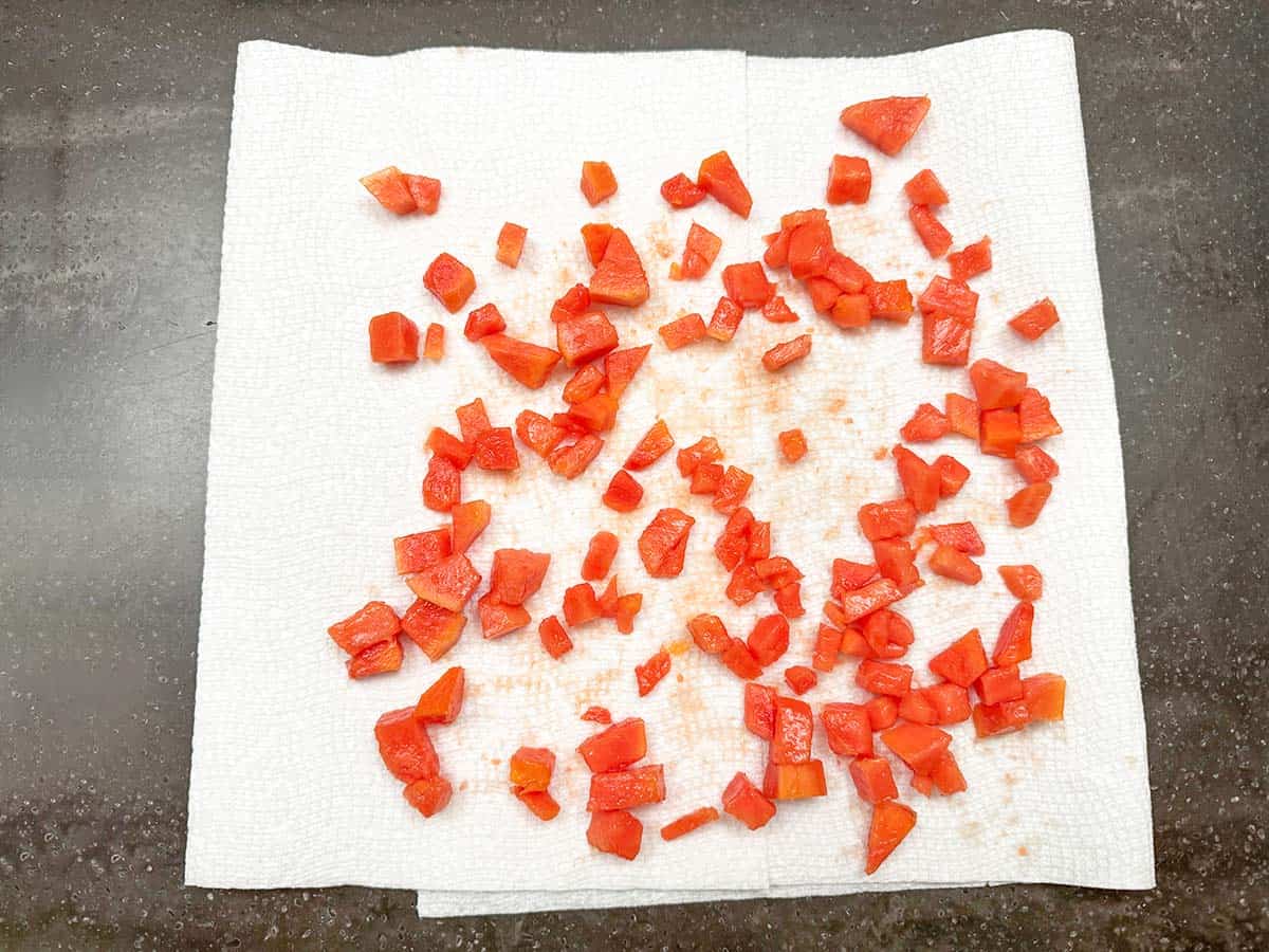 Laying the papaya pieces out onto a paper towel to aborb some of the juices.