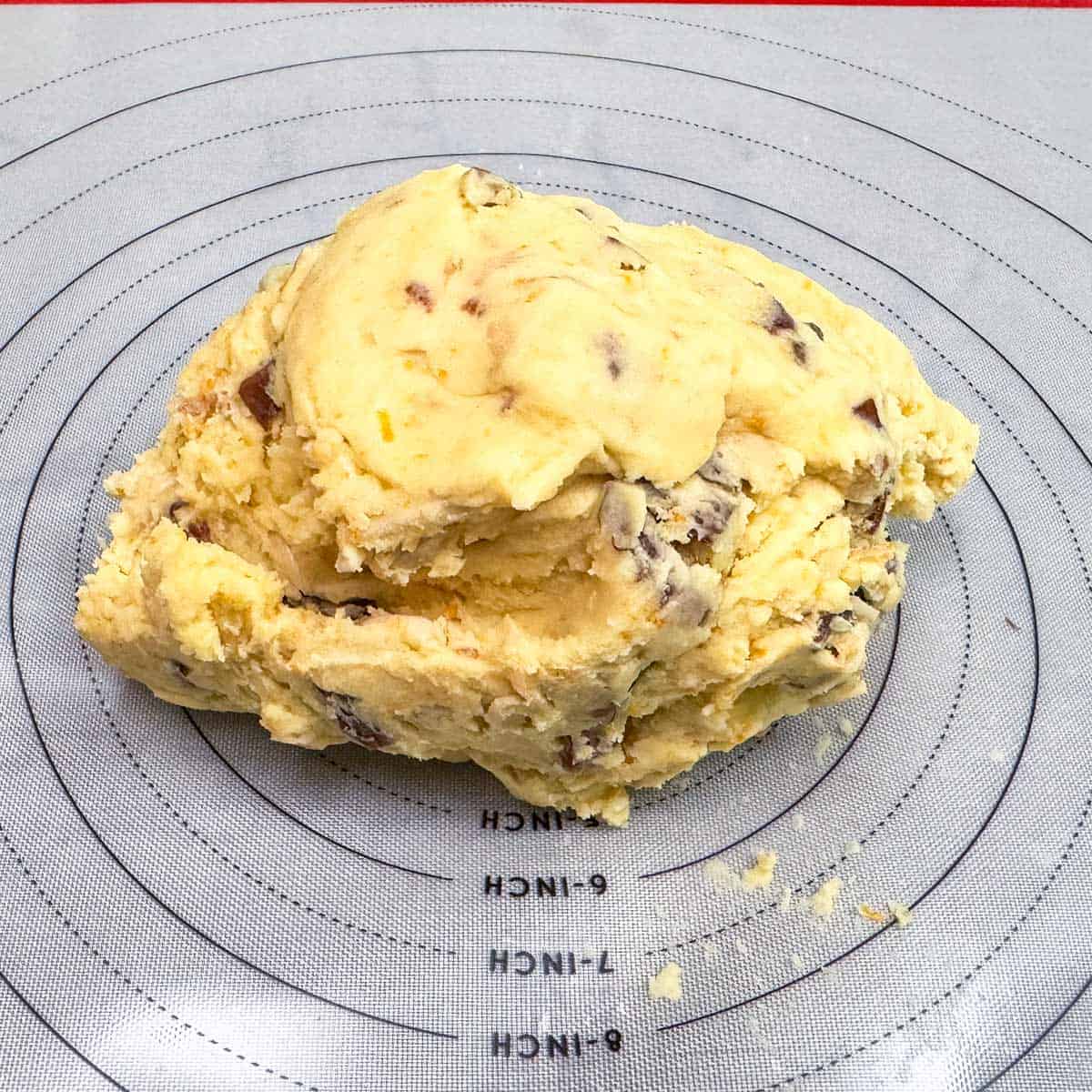 Chilled cookie dough dumped onto a pastry mat.