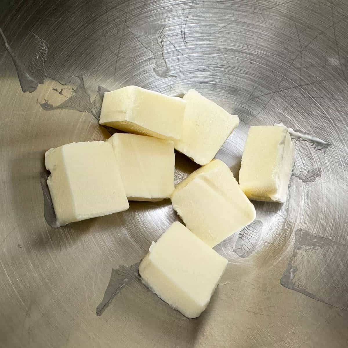 Cubed room temperature butter in a mixer bowl.