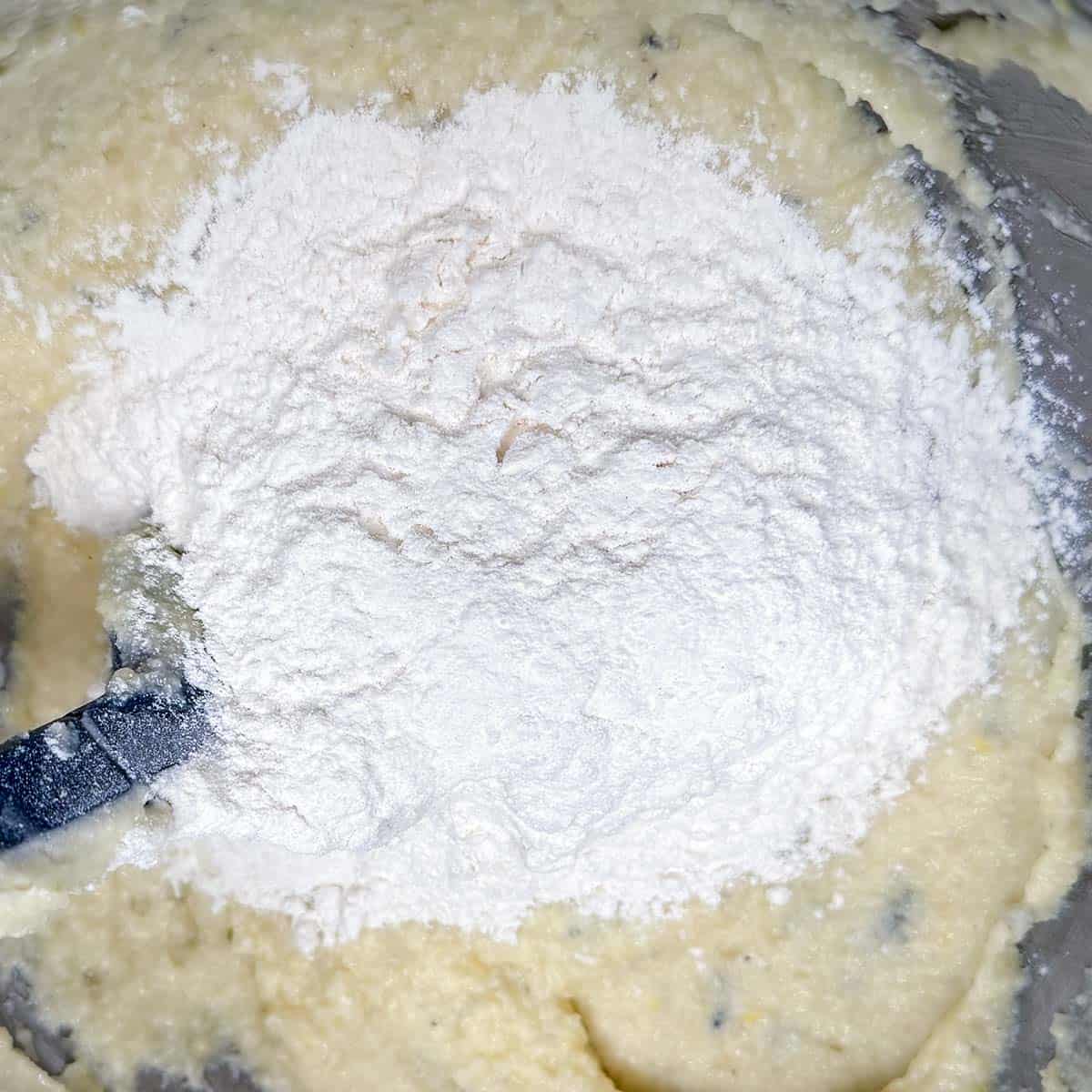 Adding flour to the cookie dough mix.