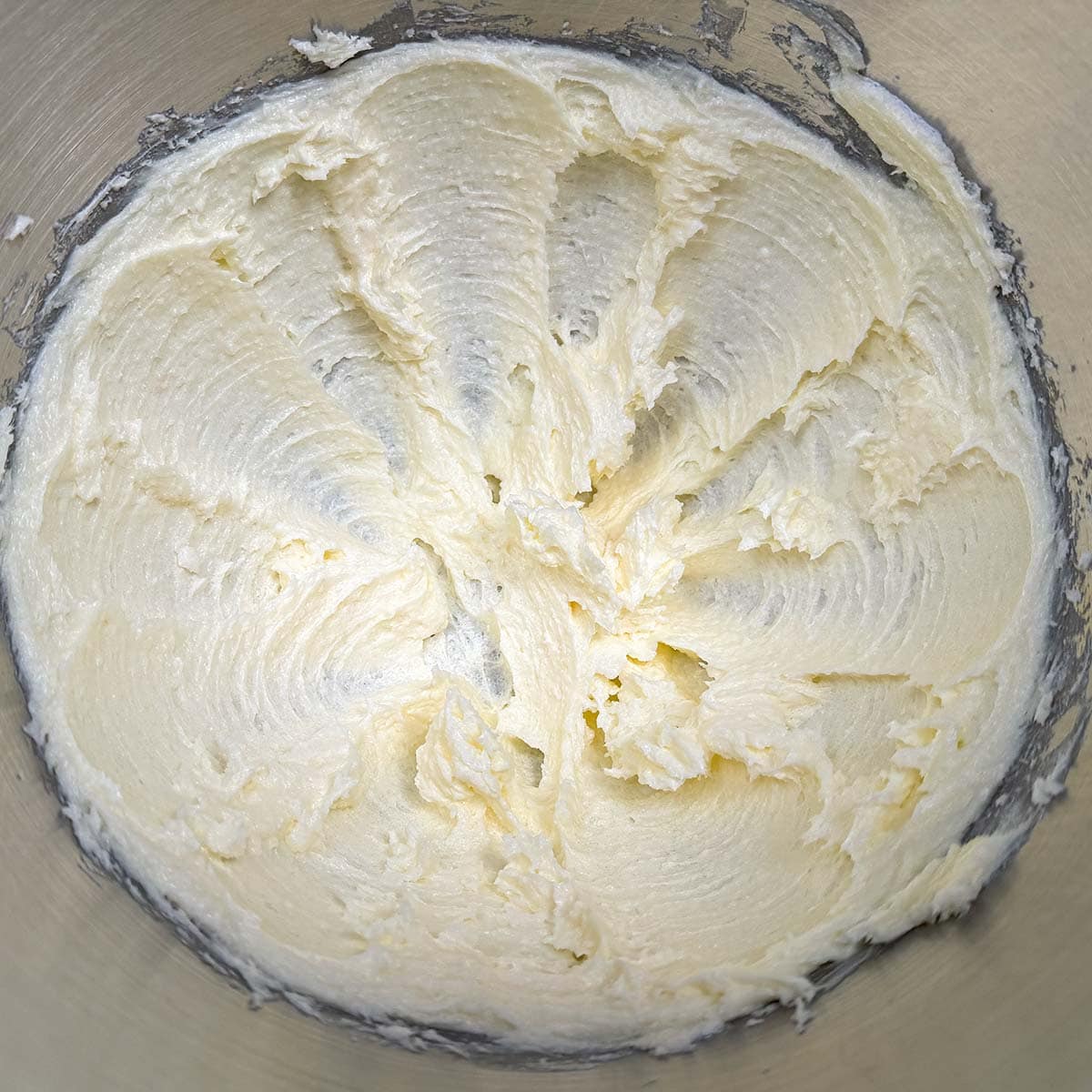Adding the sugar to the creamed butter and mix.