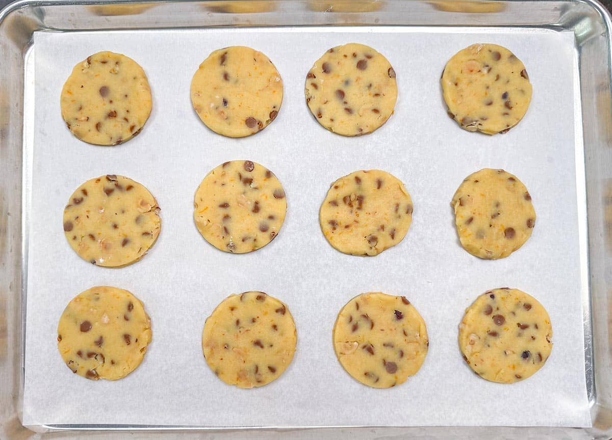 Cutout round cookie dough on a parchment lined sheet pan.