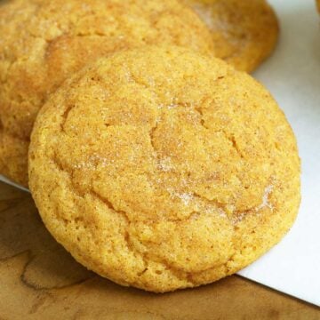 Pumpkin spice snickerdoodle cookies on a wooden plank.