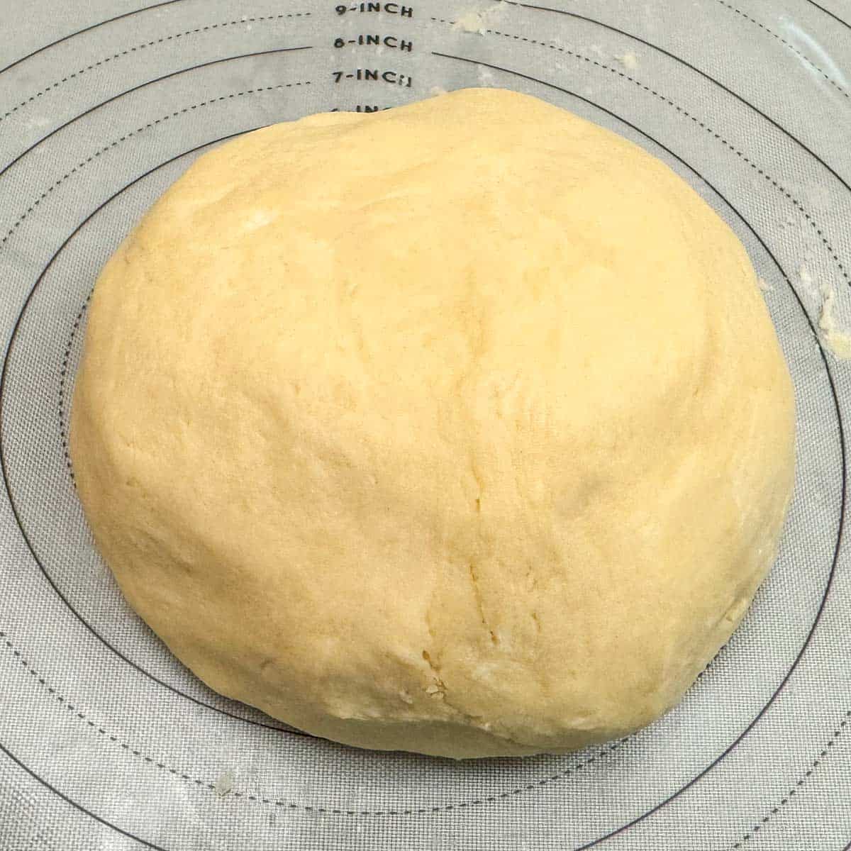 Kneading the cookie dough into a ball on a pastry mat.