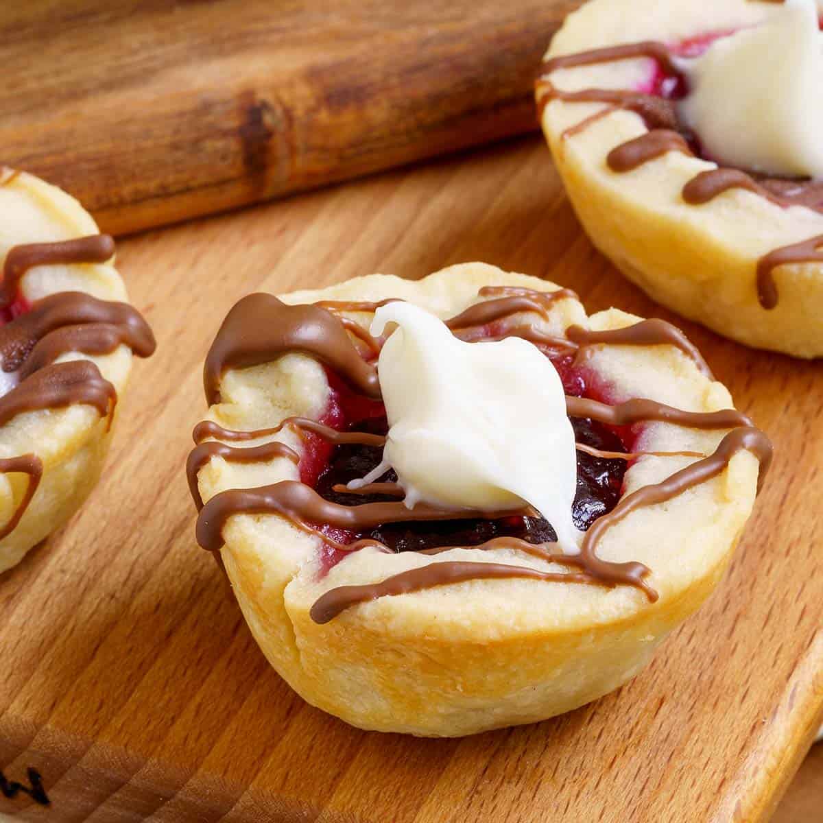 Raspberry with chocolate Cookie Cups on wooden planks-feature image.