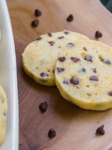 Shortbread cookies with orange anise and chocolate chips on a wooden board.