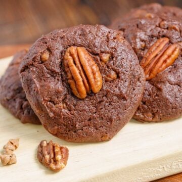 Close-up of a chocolate with caramel and pecan turtle cookies on a wooden plank