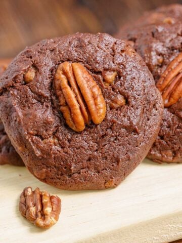 Close-up of a chocolate with caramel and pecan turtle cookies on a wooden plank