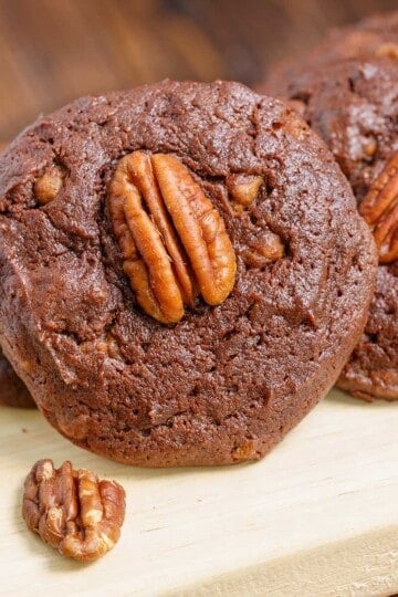 Close-up of a chocolate with caramel and pecan turtle cookies on a wooden plank