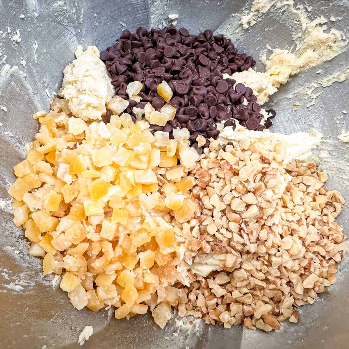 Adding orange peel, walnuts and chocolate chips to the cookie batter.