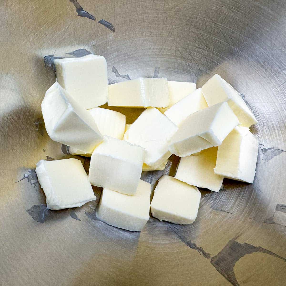 Two sticks of butter that has been cubed and in a mixer bowl.