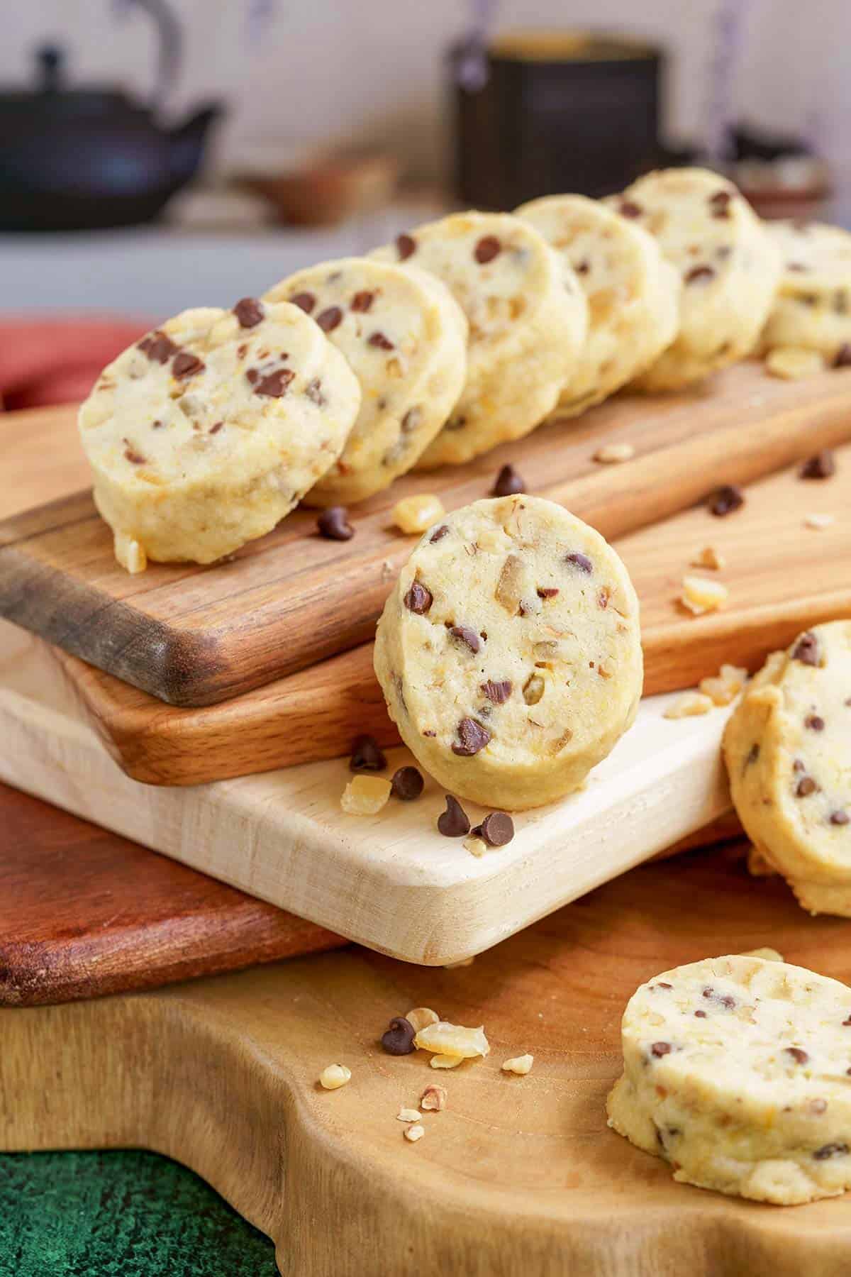 Chocolate with walnuts and orange peel shortbread cookies on wooden cutting boards.