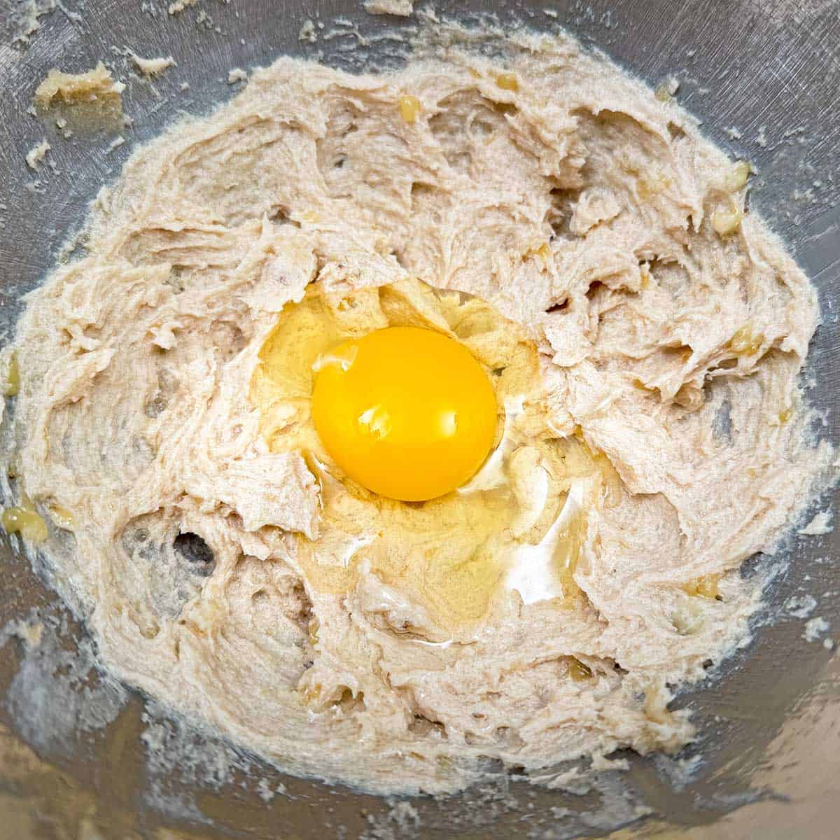 Adding the egg to the cookie dough.