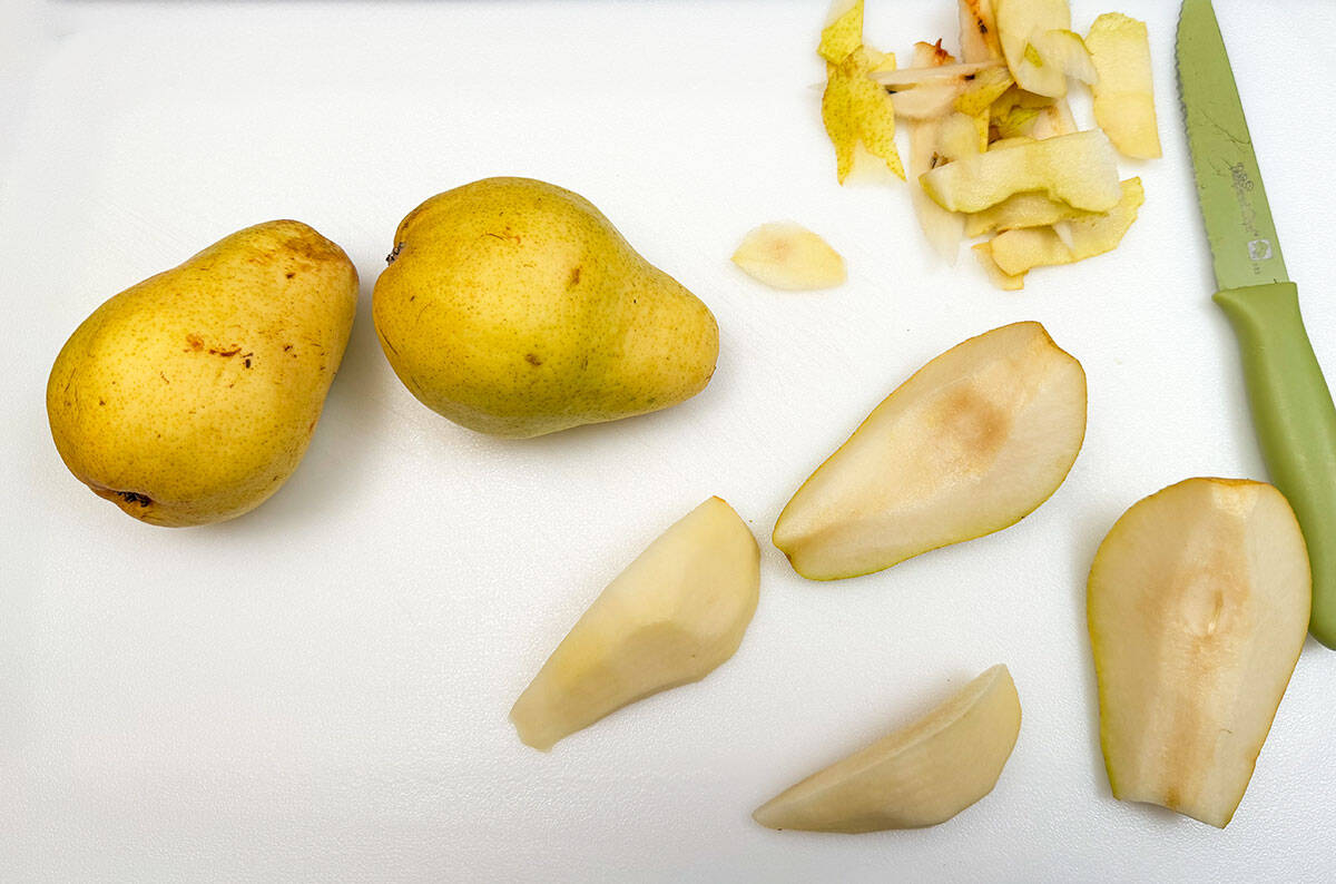 A pear quartered and the outside skin taken off.