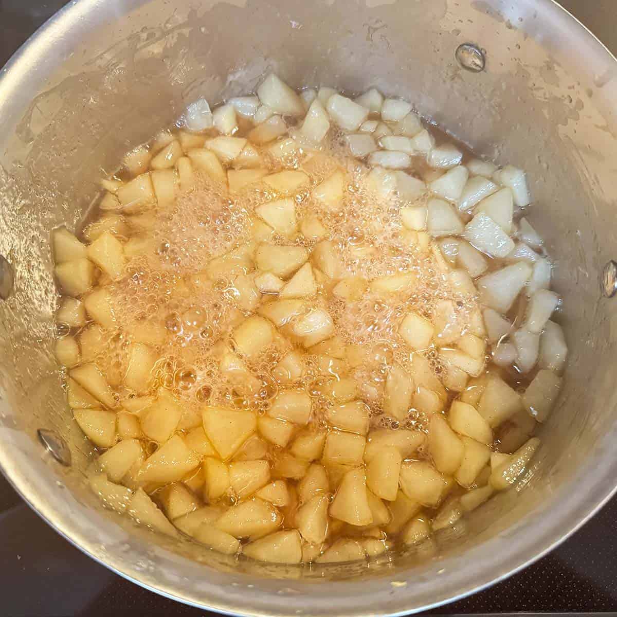 Reducing the pear liquid over a medium-high heat.