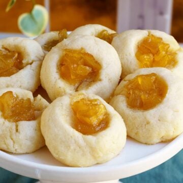 Finished thumbprint cookies with pear filling on a dish.