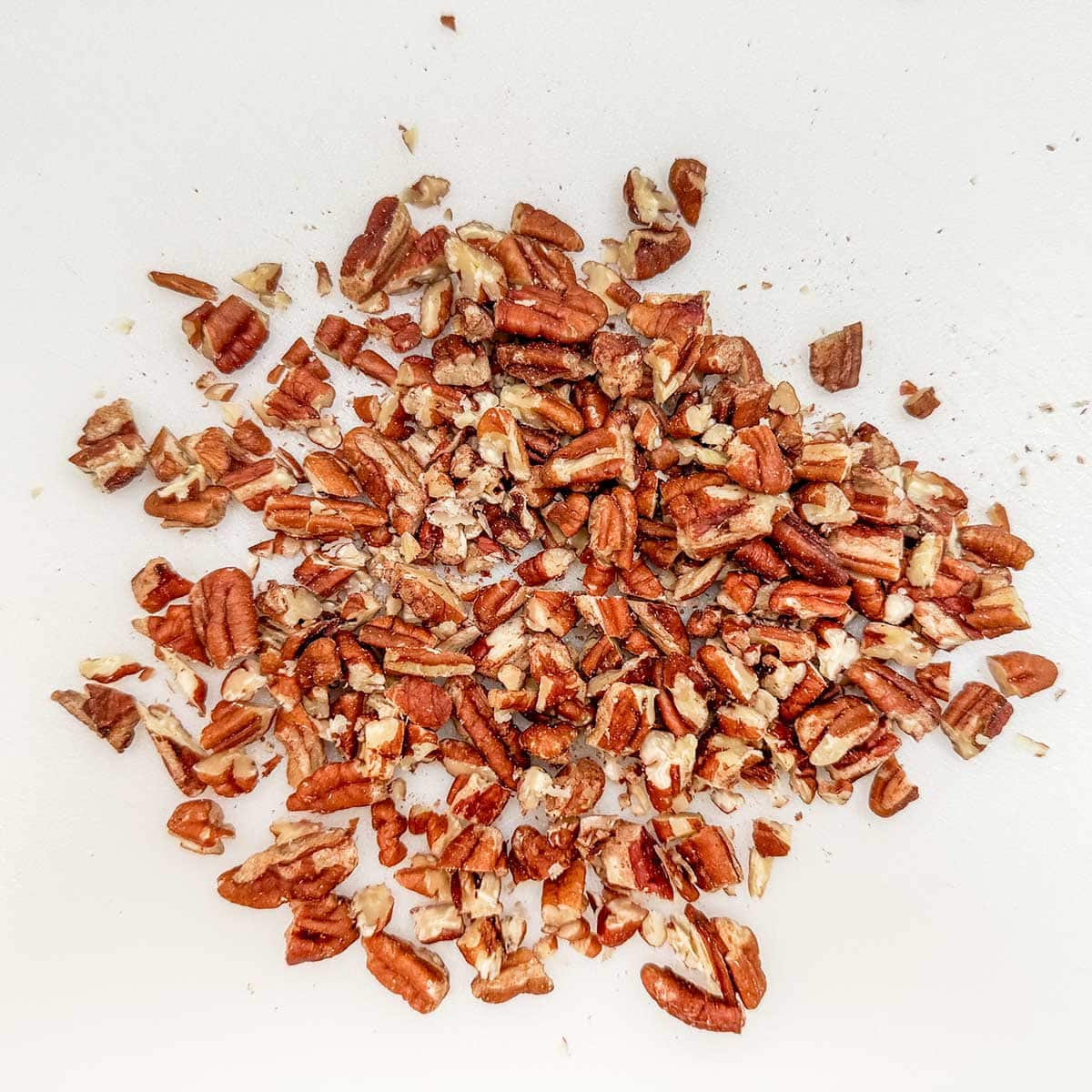 Chopping pecans that will go on top of the crumble part of the cookie.