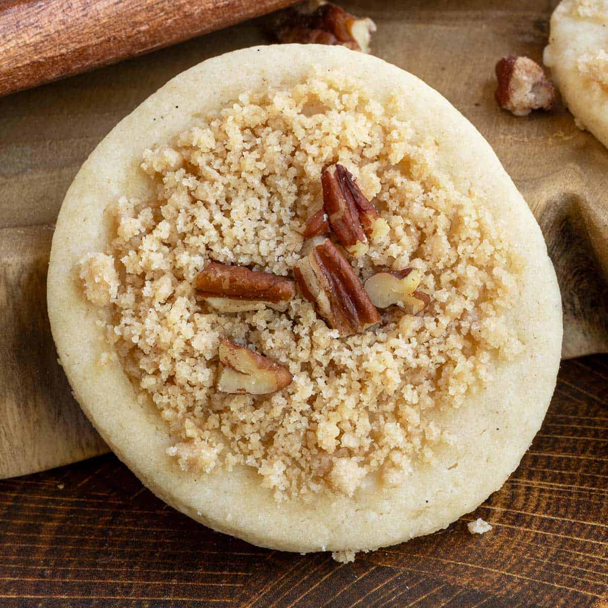 Cookie with cruble topping on a wooden board.