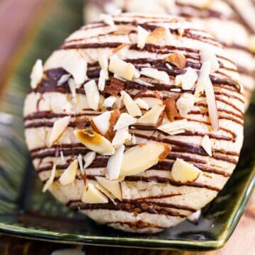 Closeup of a finished Italian almond cookie with bittersweet chocolate on a plate.