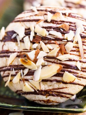 Closeup of a finished Italian almond cookie with bittersweet chocolate on a plate.