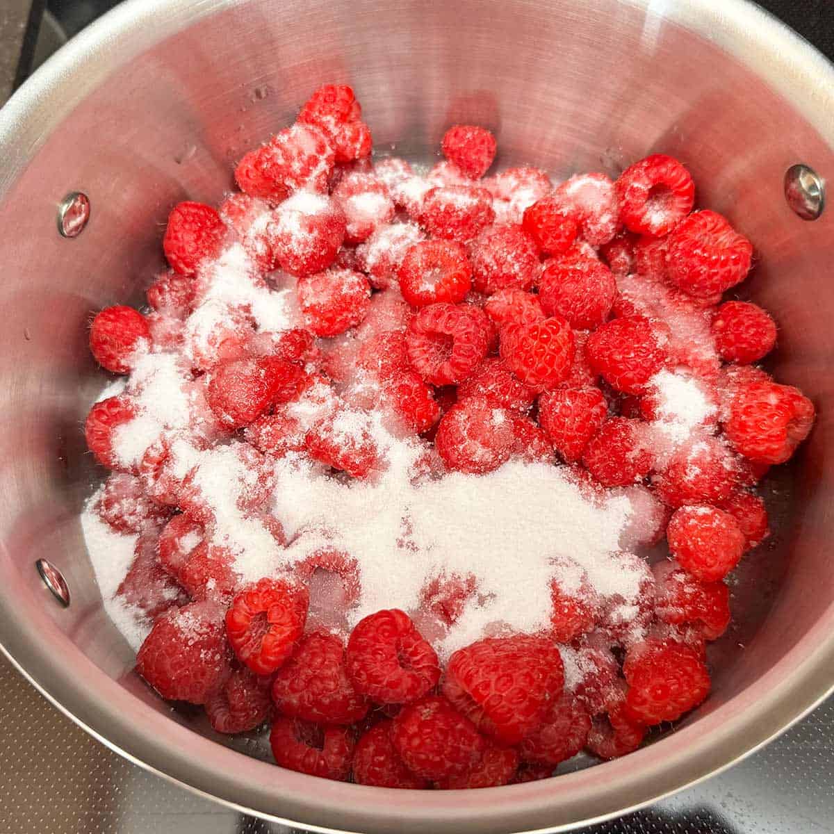 Washed raspberries with the sugar added in a 3qt saucepan.