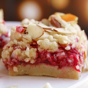 Raspberry white chocolate almond shortbread bars sitting on a plate.