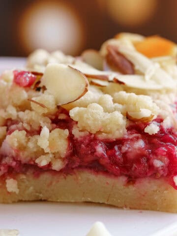 Raspberry white chocolate almond shortbread bars sitting on a plate.