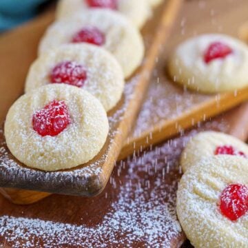 Feature image of the ready for christmas whipped shortbread cookies on a wooden board.