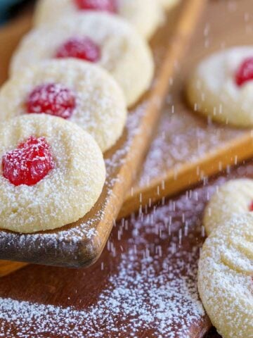 Feature image of the ready for christmas whipped shortbread cookies on a wooden board.