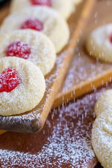 Feature image of the ready for christmas whipped shortbread cookies on a wooden board.