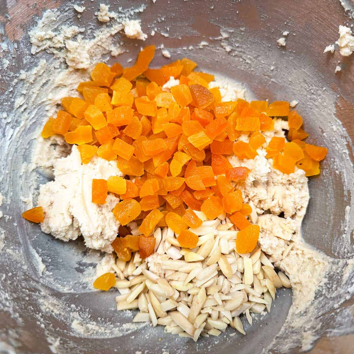 Adding the cut-up apricots and almonds to the cookie dough.