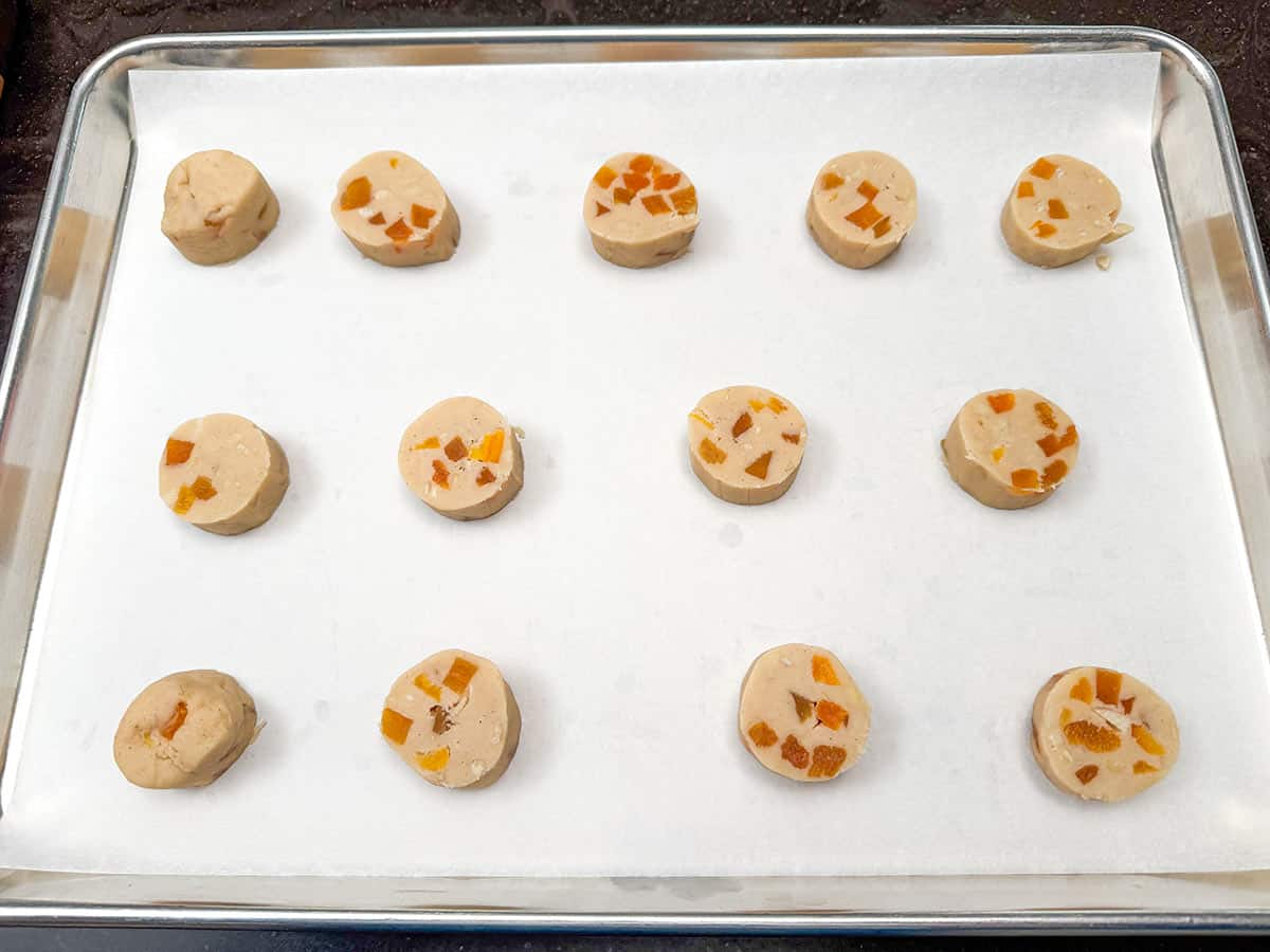 Placing the slices from one roll onto a parchment lined cookie sheet pan.