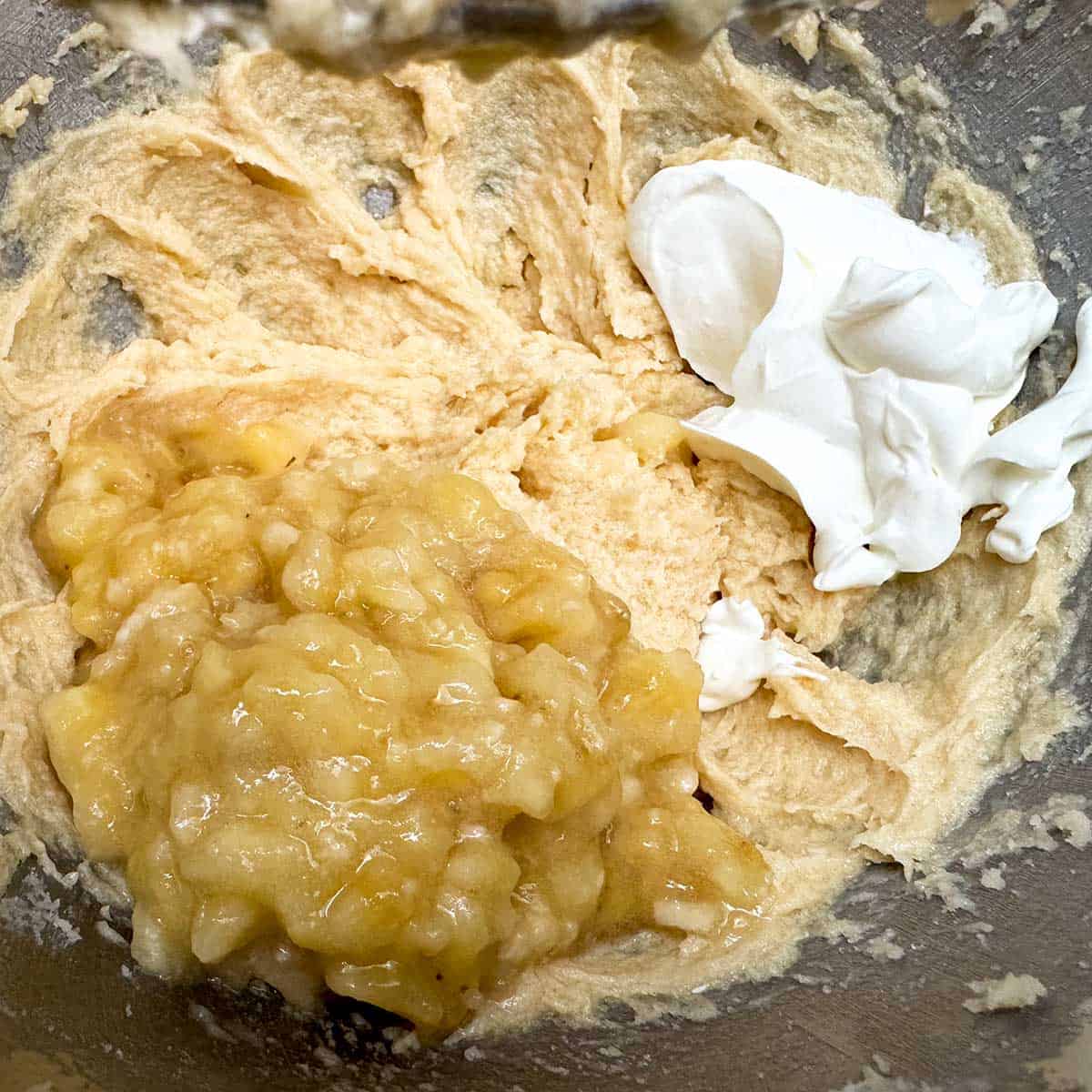 Adding smashed bananas and sour cream to the wet cookie ingredients.