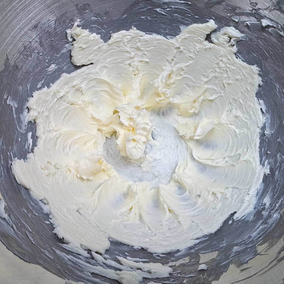 Cubed butter that has been creamed in a mixer bowl.