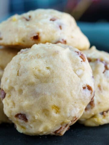 Banana pecan cookies with caramel chips sitting on a black board.