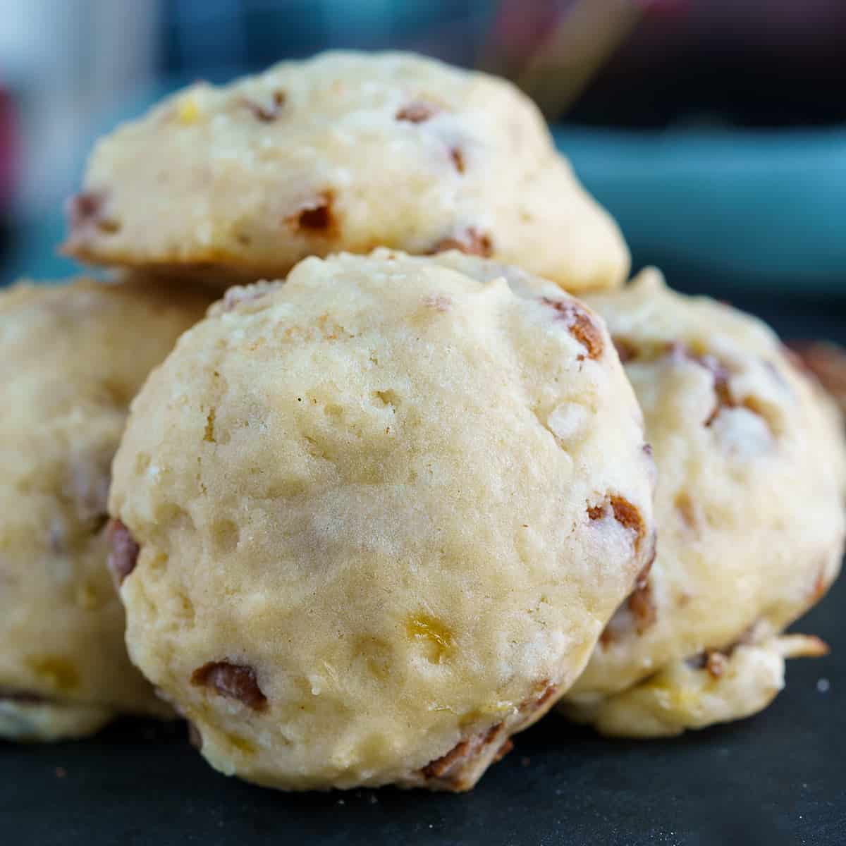 Banana pecan cookies with caramel chips sitting on a black board.