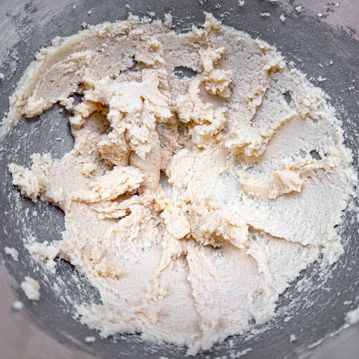 Butter and sugars mix together in a mixer bowl.